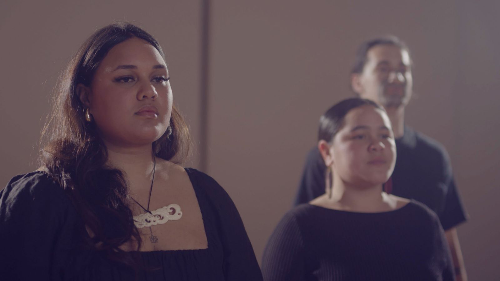 A close up of three people singing a song.