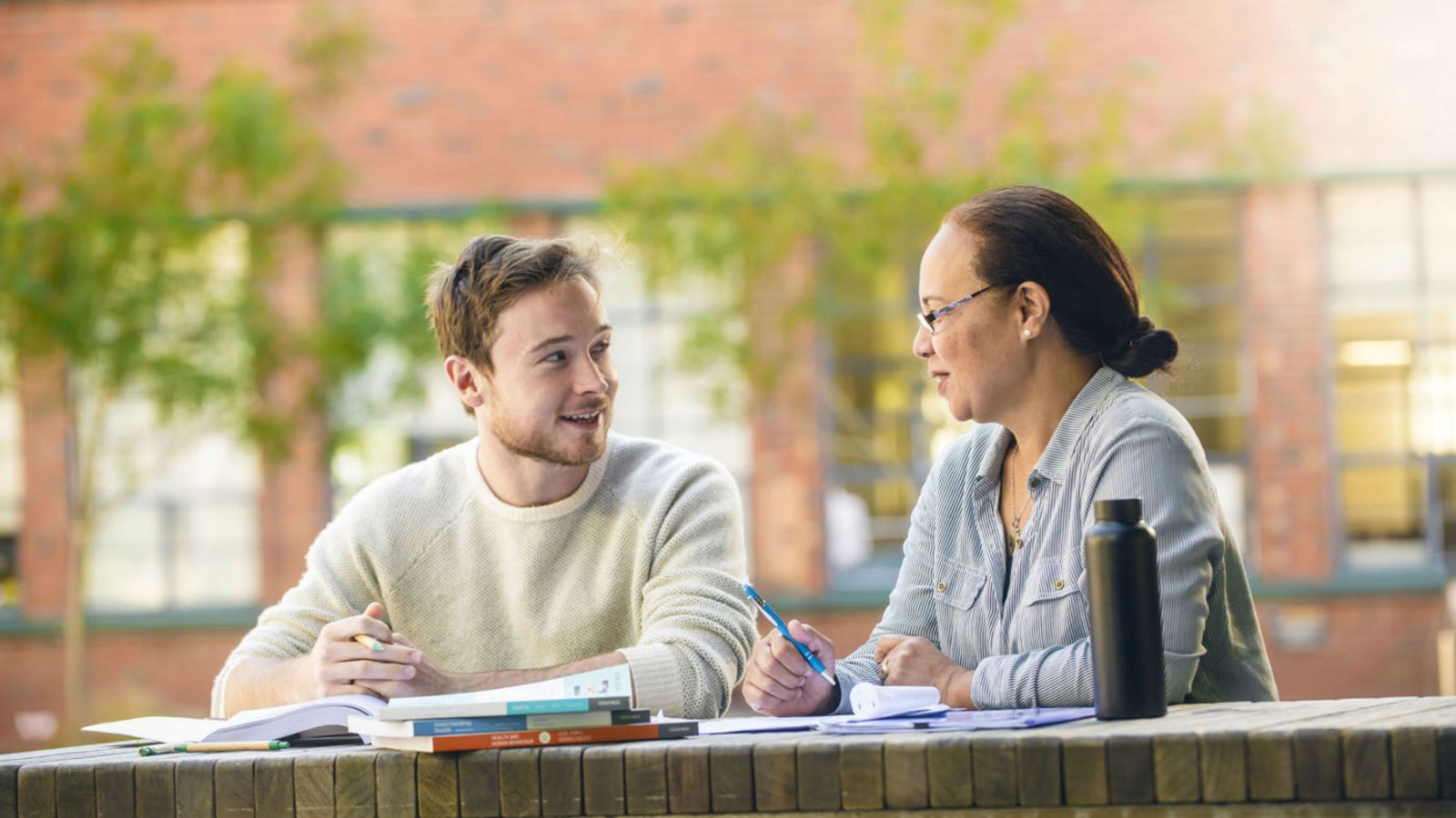 Two postgraduate students studying outside