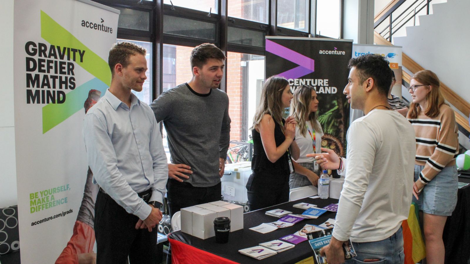 A male student engages with employers at an expo booth.