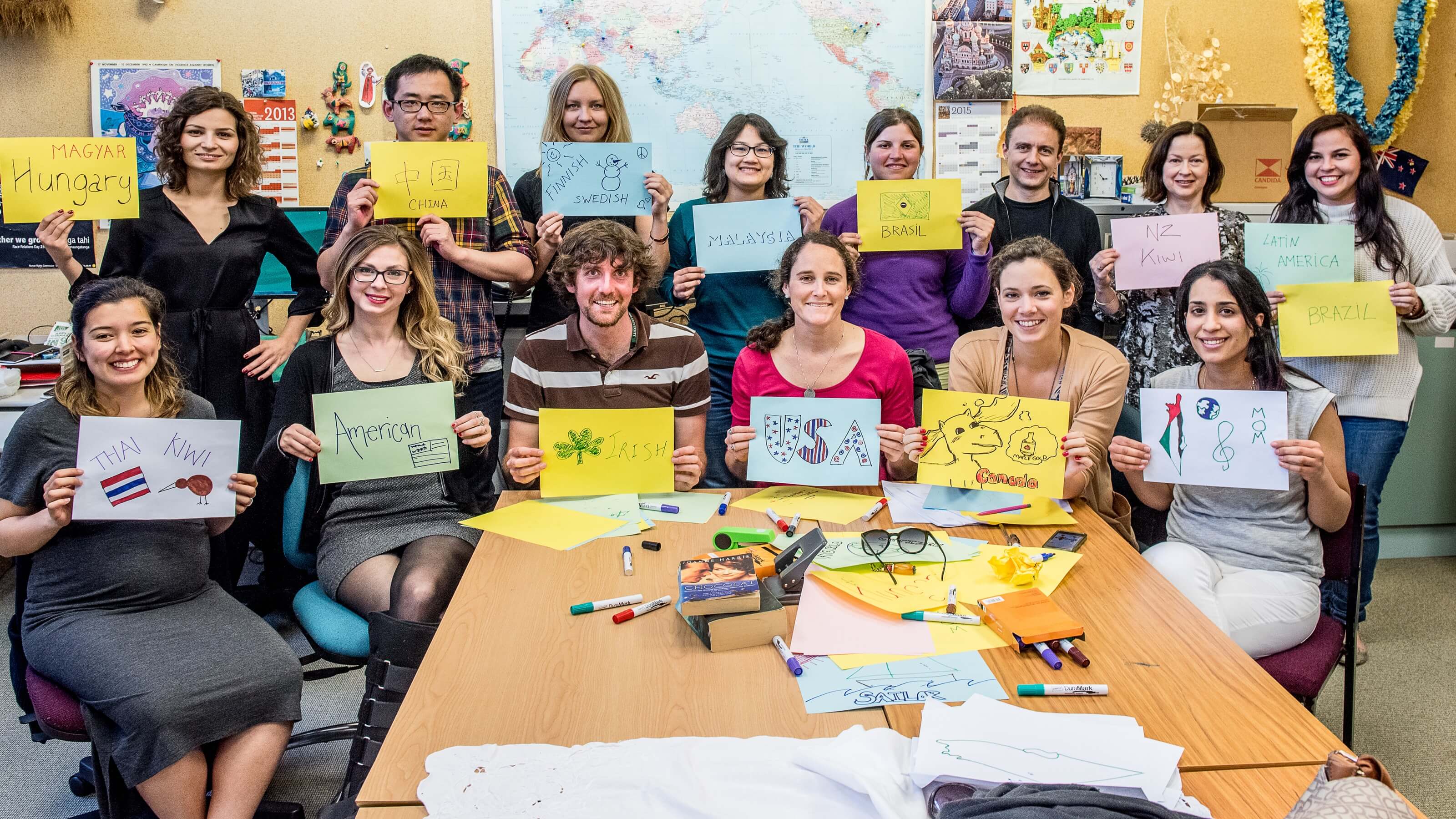 CACR students hold up drawings with the name of the country they're from.