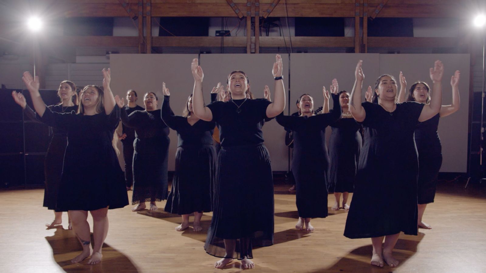 A group of women with their hands in the air performing.