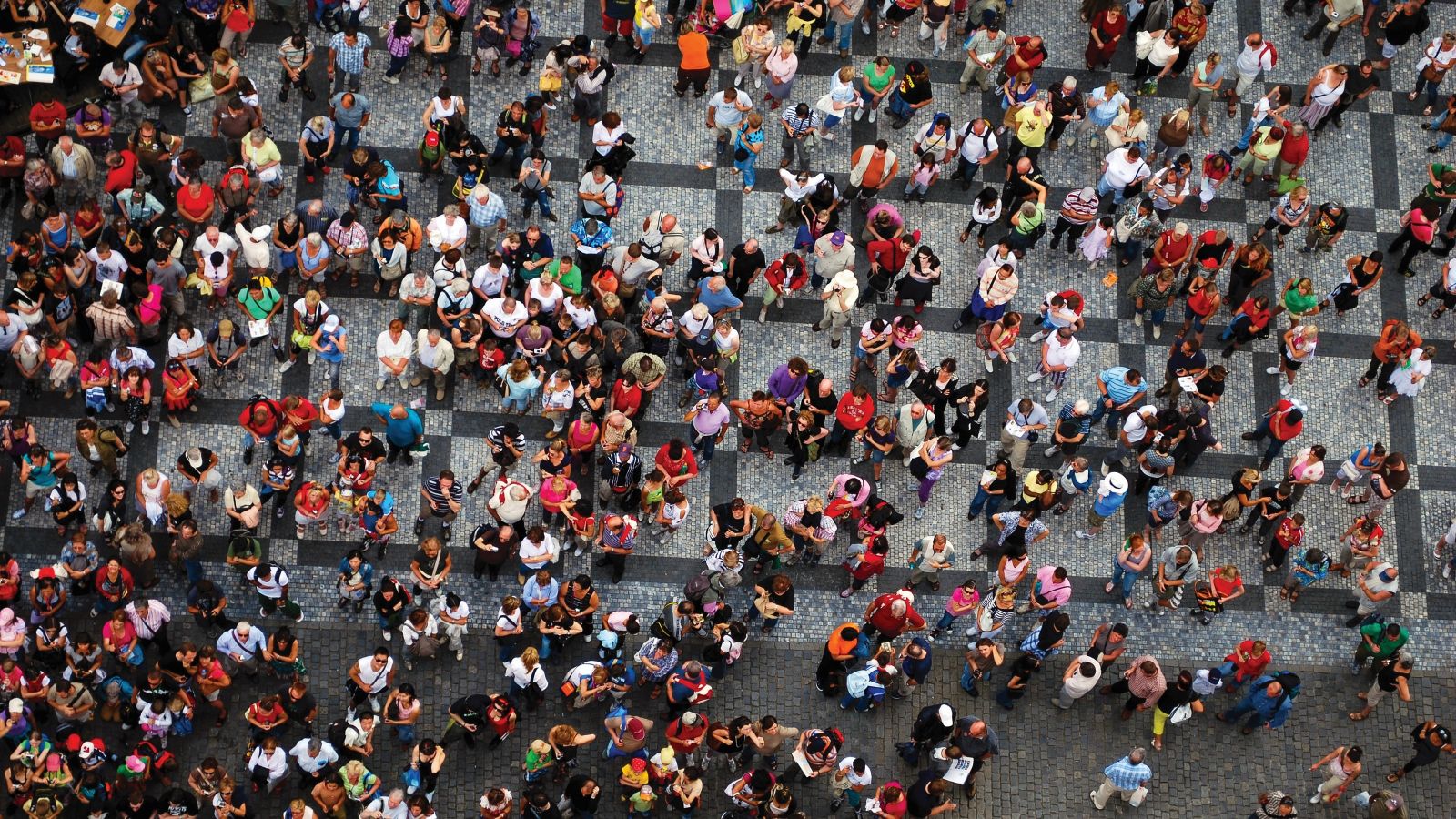 An aerial shot looking down at a large group of people in a paved area