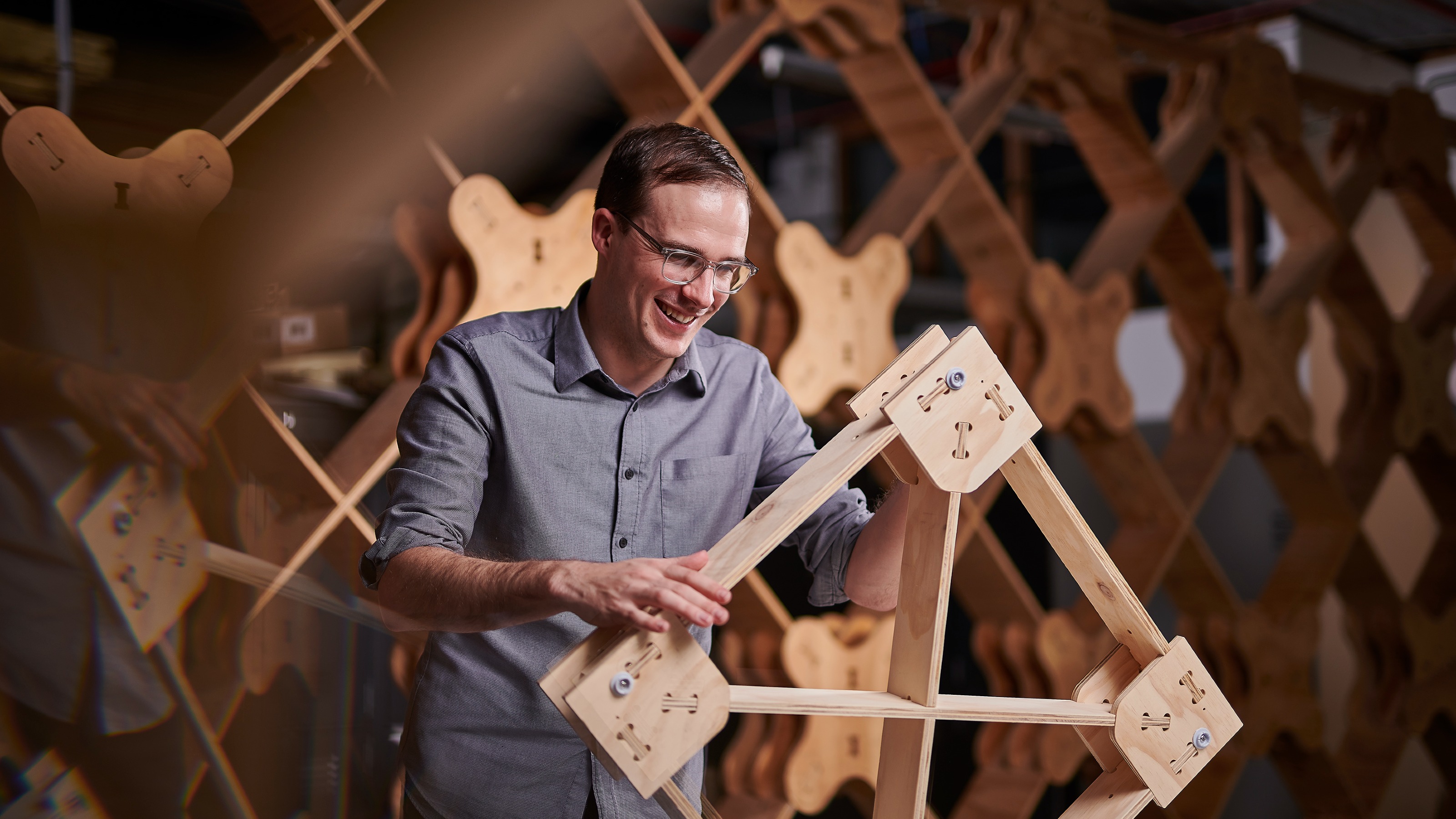 PhD student Ged Finch stands in front of the building system he developed