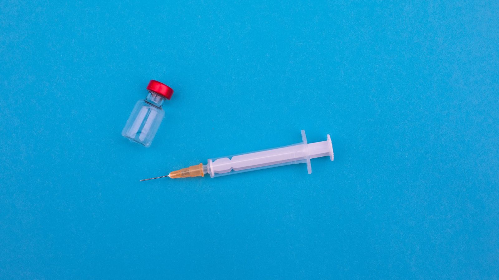 A medical needle next to a sample bottle