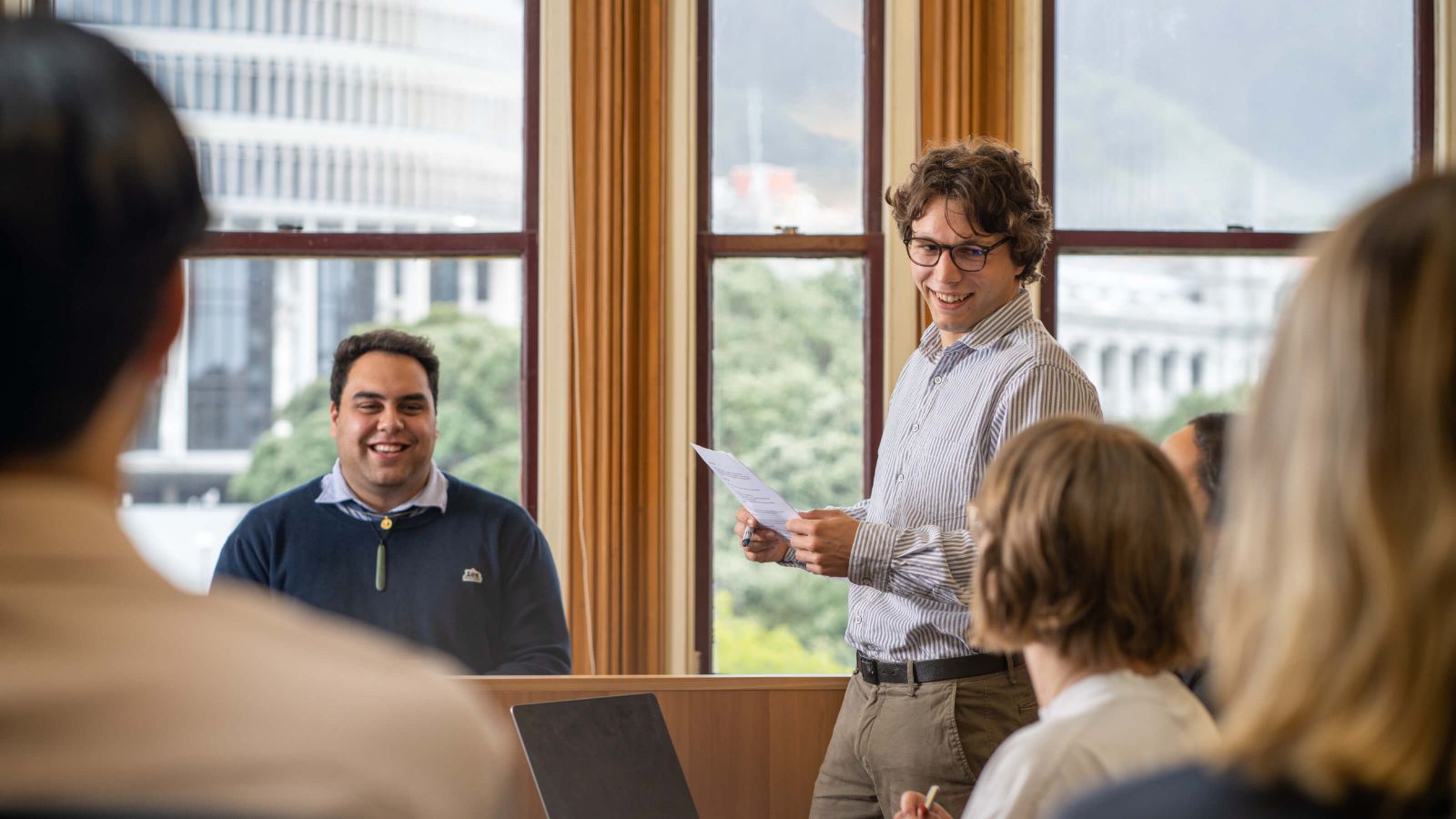 A group of undergraduate students taking part in a moot in a seminar room at the Law School.