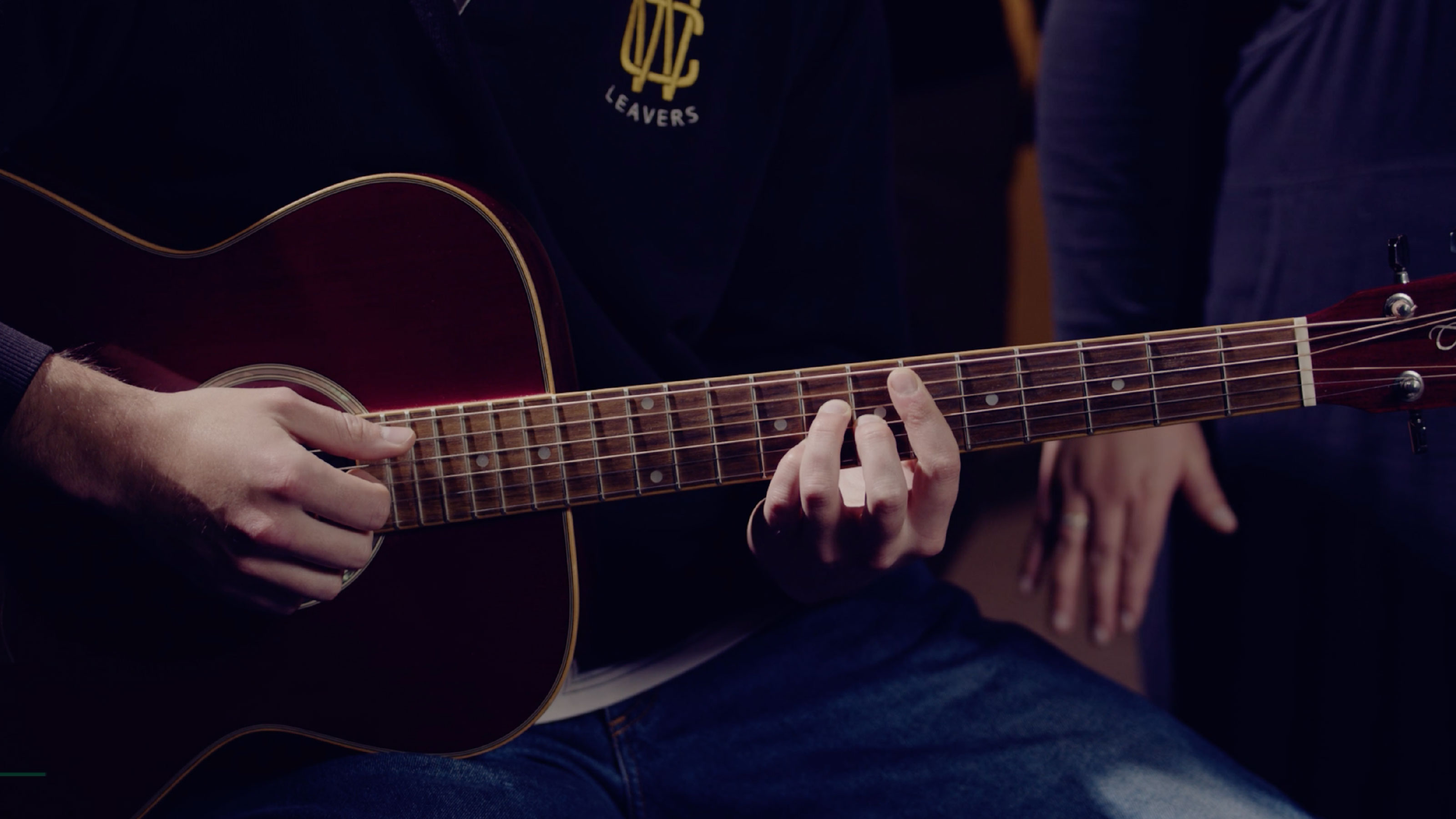 A close up of a person playing a guitar.