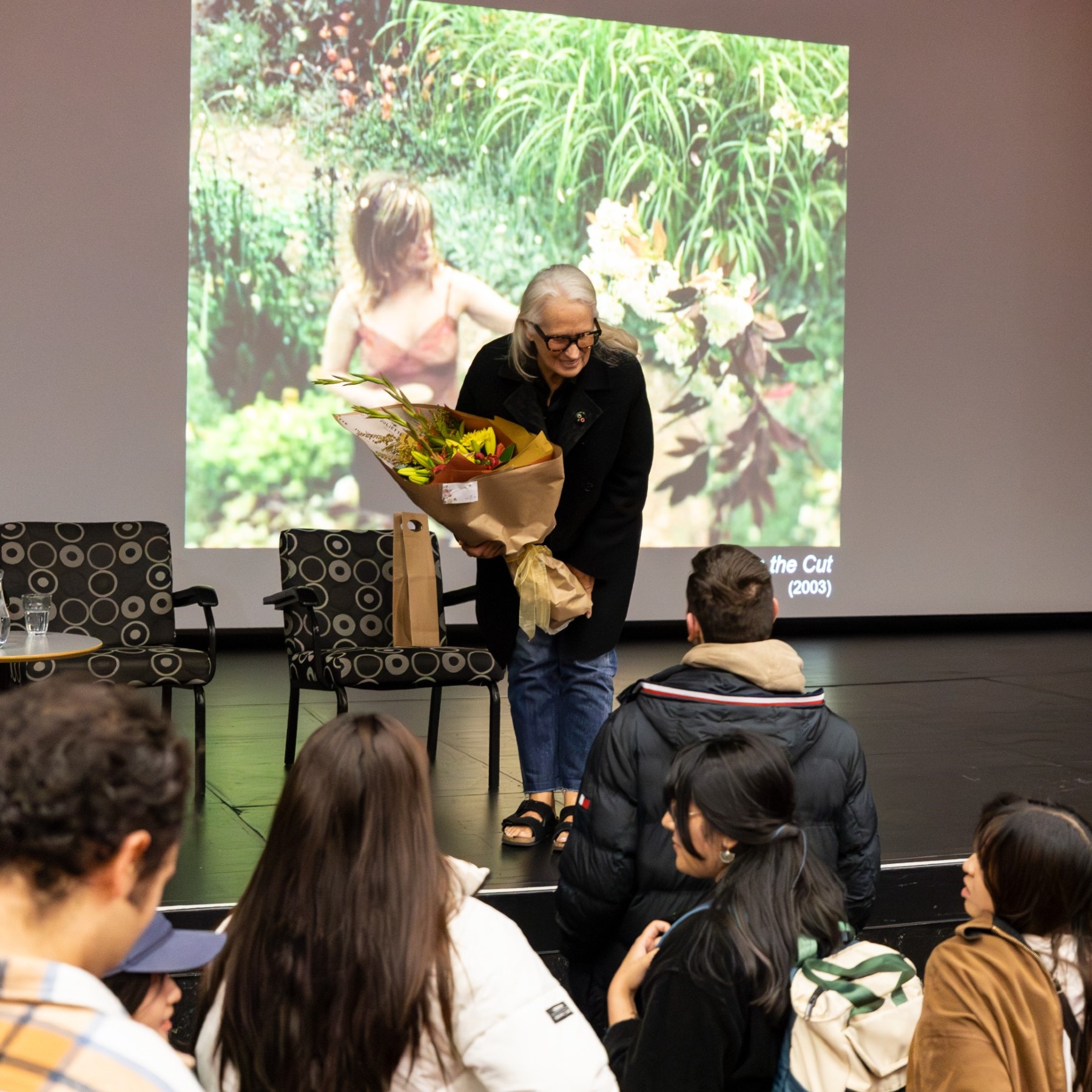 Jane Campion stands on stage talking to students