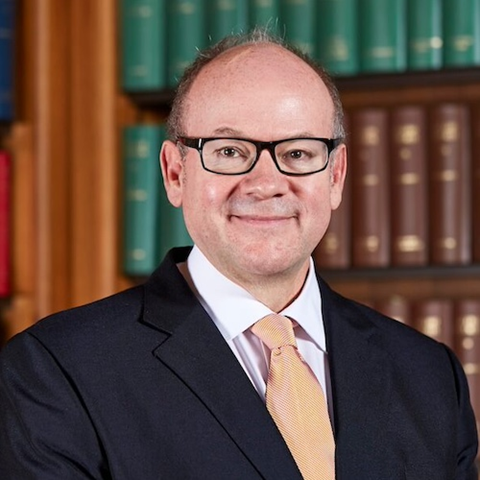 Man wearing glasses, smiling at camera