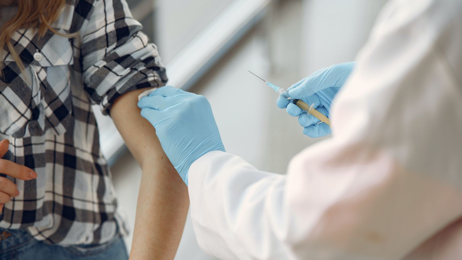 Person getting injection in left arm 