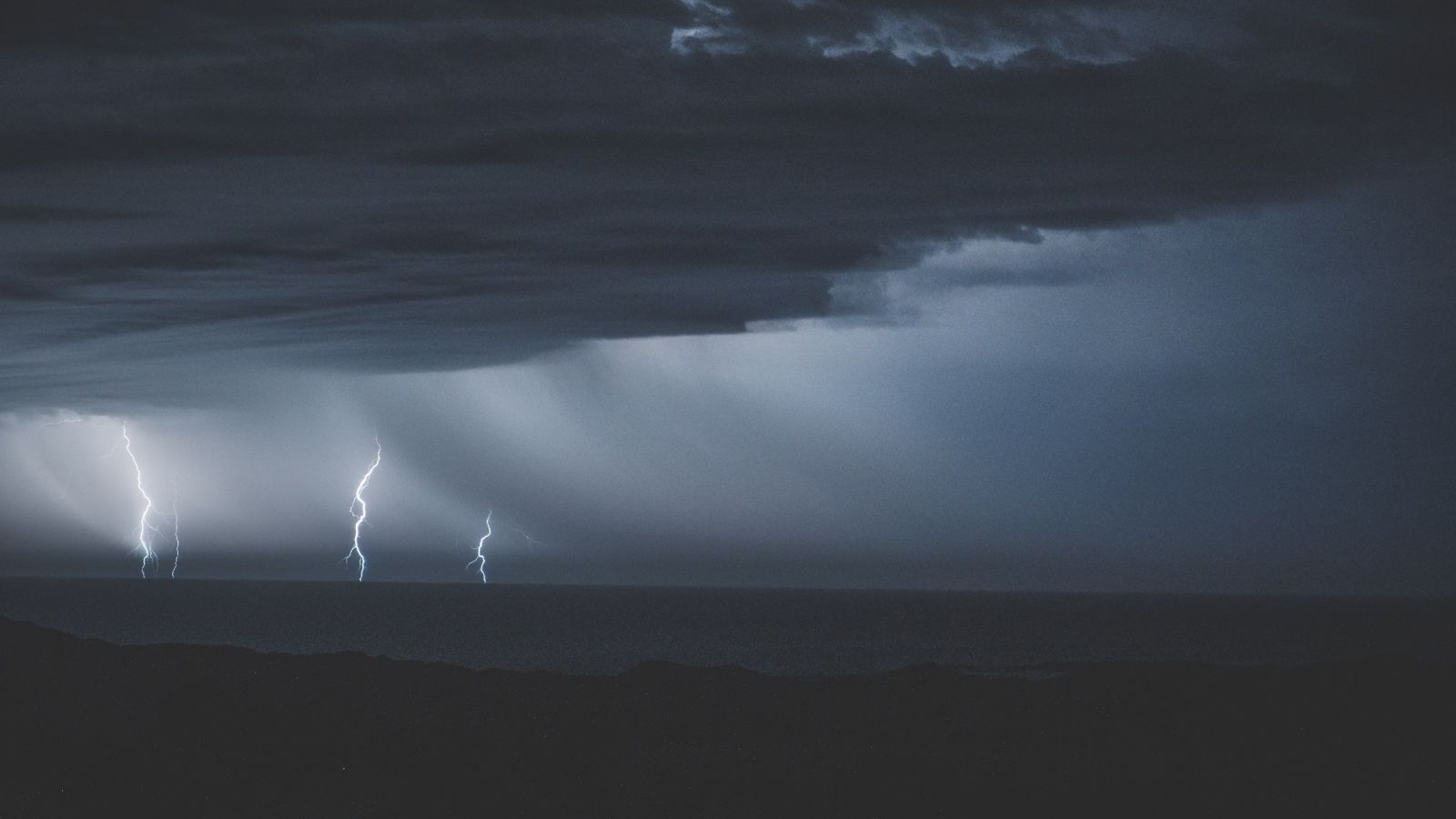 Lightning strike in the sky over a turbulent sea