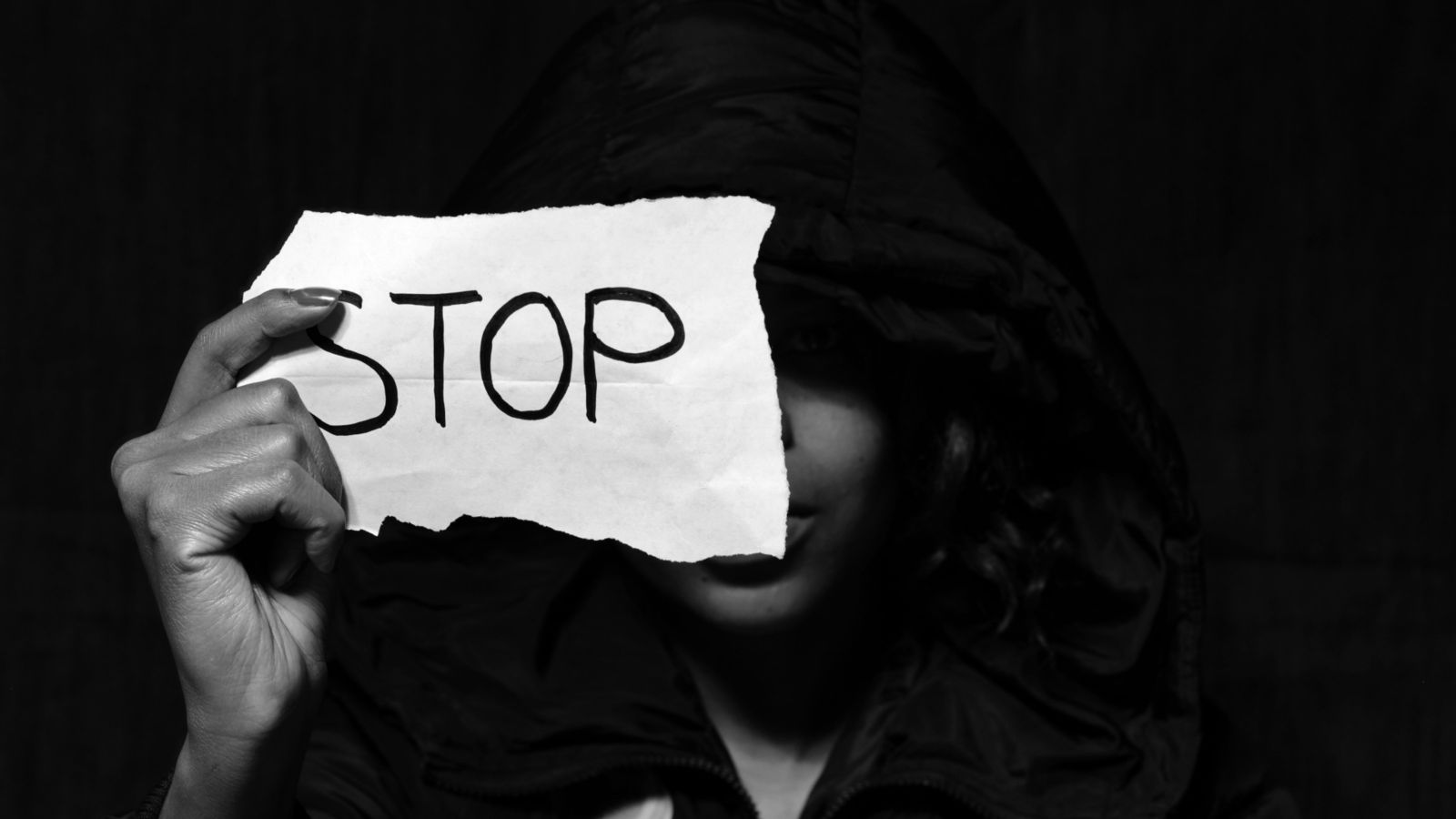 Woman holding a piece of paper with the word 