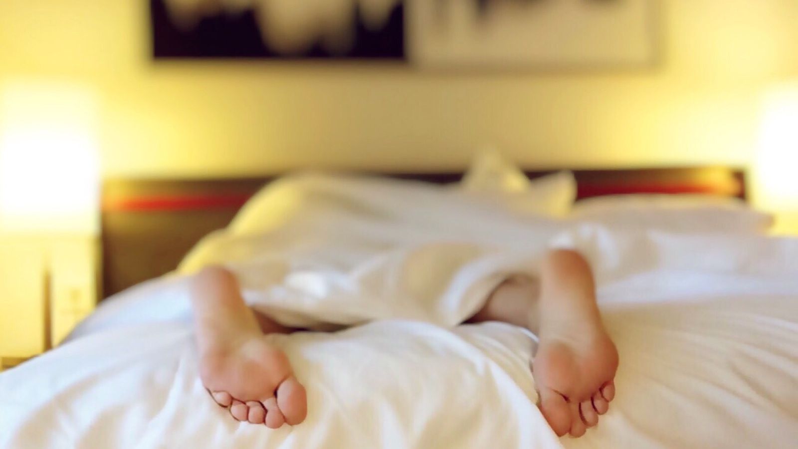 Person in bed, covered by white blanket