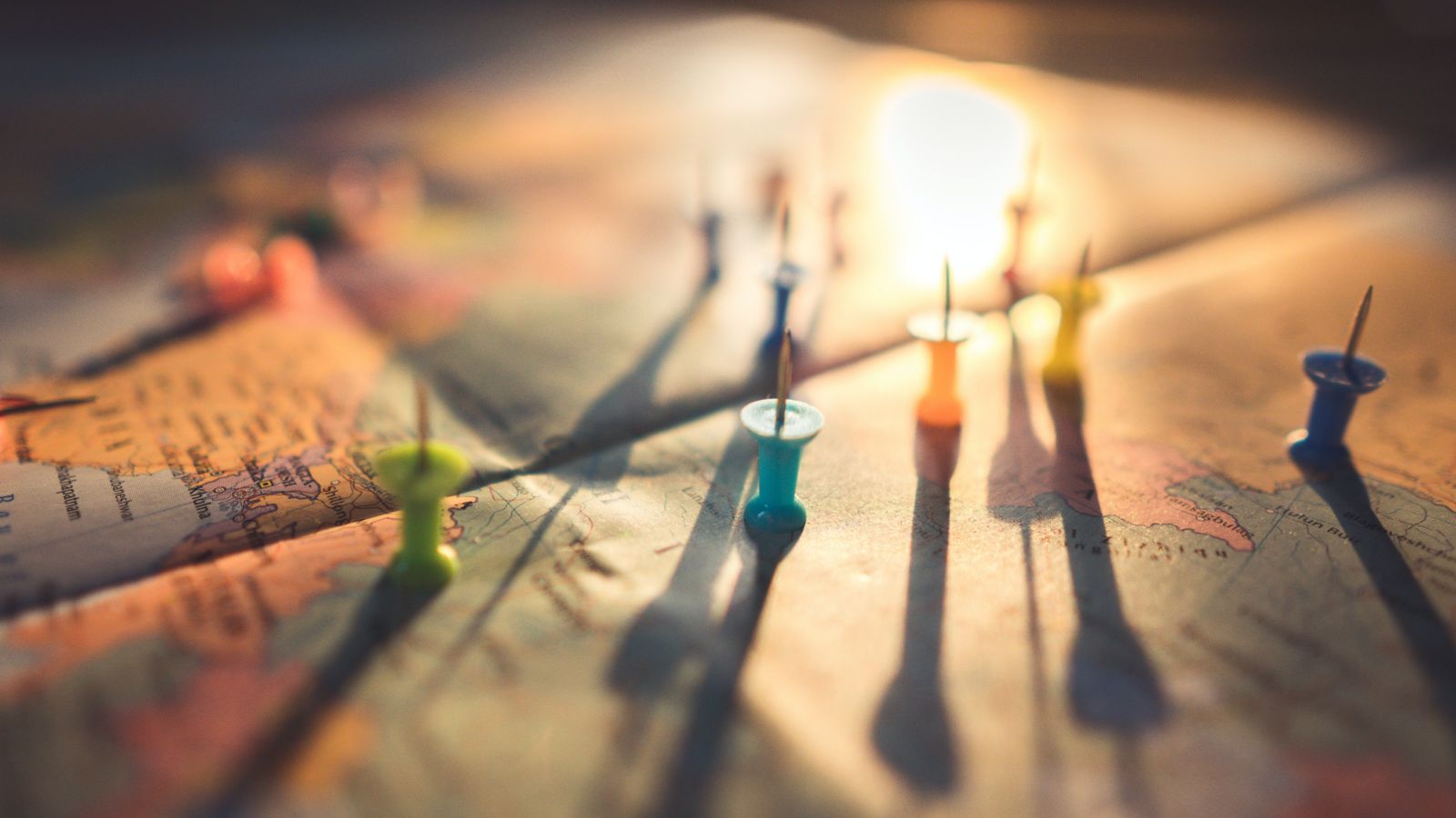 Close up photo of world map with assorted coloured pins