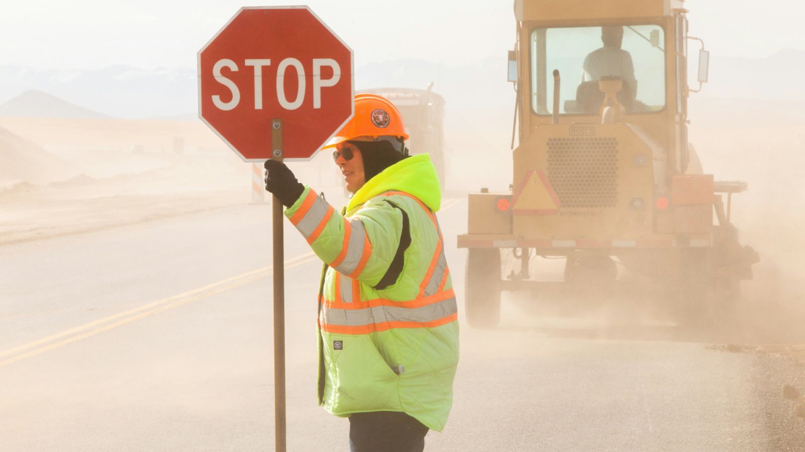 Road worker holding a 'Stop' sign  
