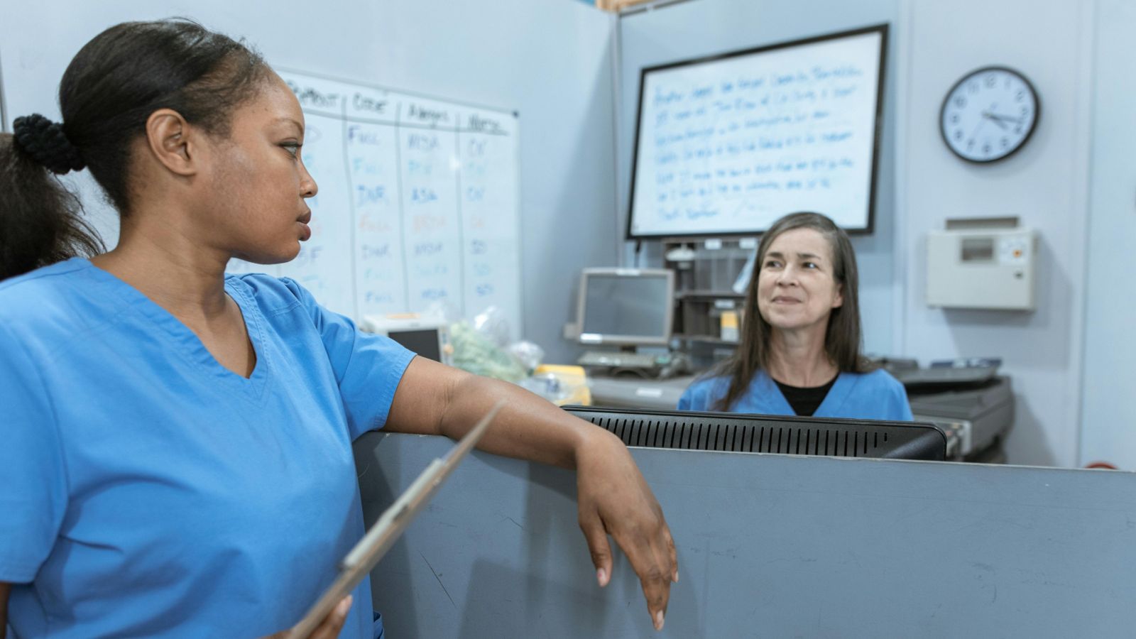 Two people in blue hospital scrubs 