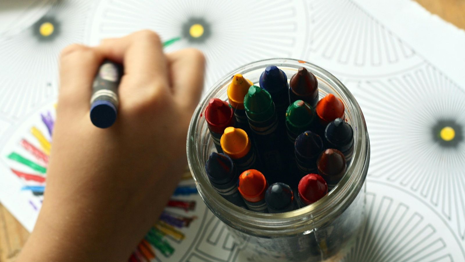 Child drawing with crayons 