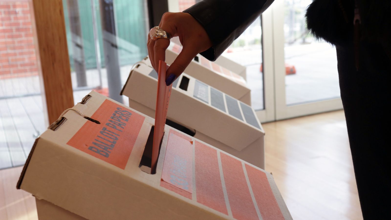 Person putting voting paper in ballot box