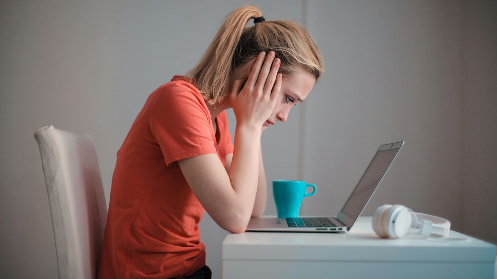 Person staring at laptop and looking confused