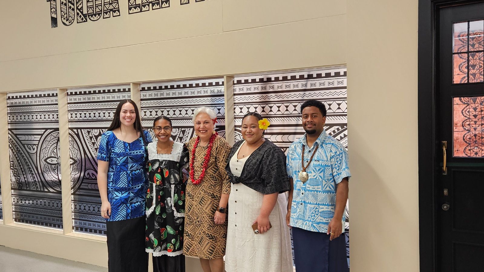 A group of Pasifika people standing in front of the new Toloa Lapita study space.