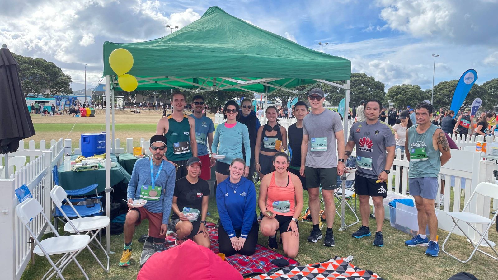 Group of people together under a gazebo after competing in Round the Bays