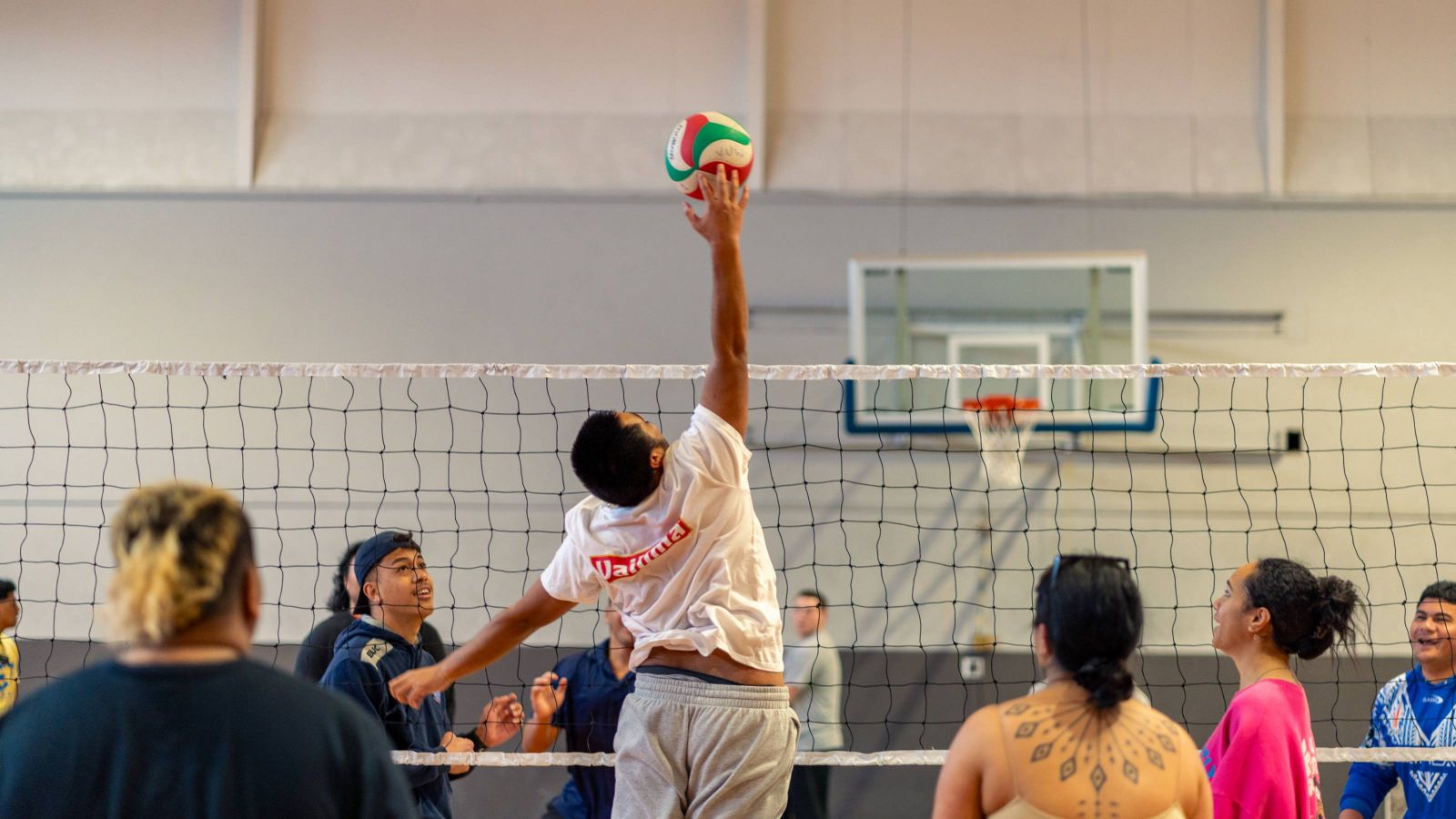 A volleyball player rises high for a spike