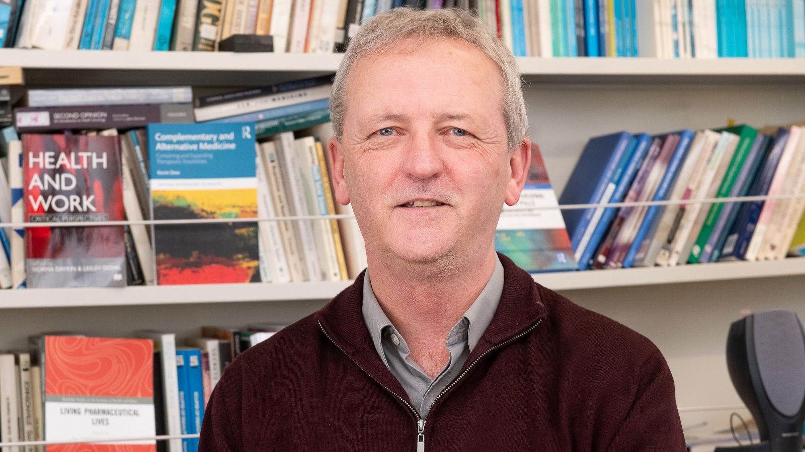 man standing in front of bookshelf