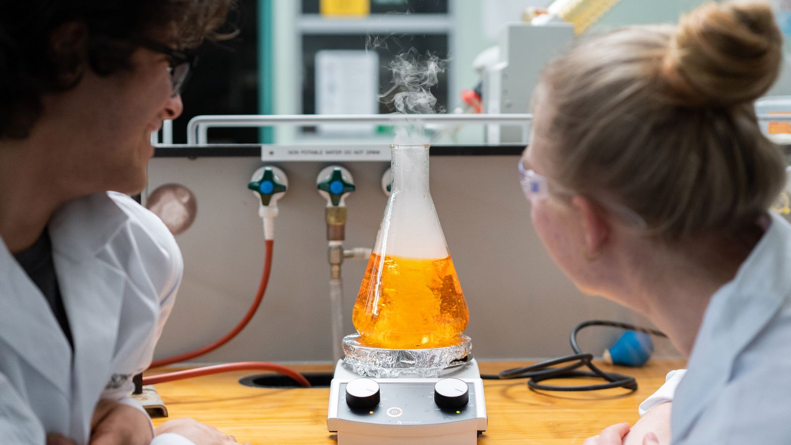 Chemsitry students looking at liquid in a flask. Image copyright Victoria University of Wellington.