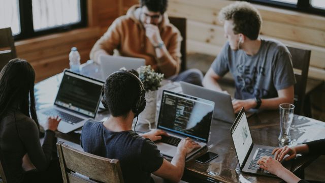 Photo of people sitting together working on laptop computers