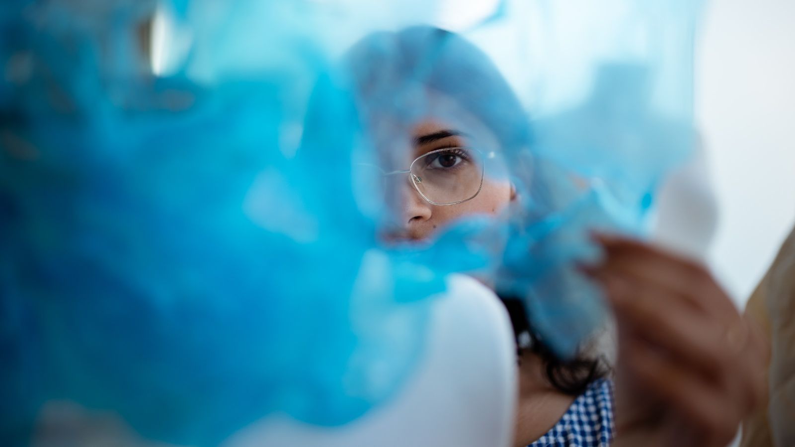 Woman looking through blue material